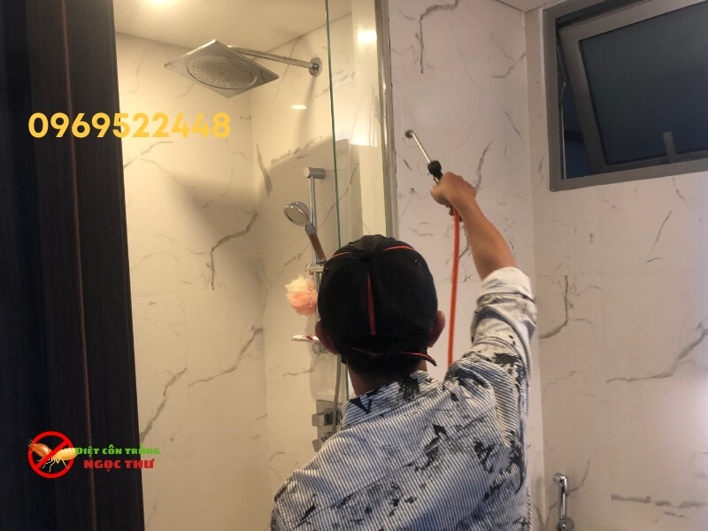 Kỹ thuật viên Ngọc Thư đang phun thuốc tồn lưu diệt kiến cho căn hộ chung cư tại quận 2, TP.HCM
